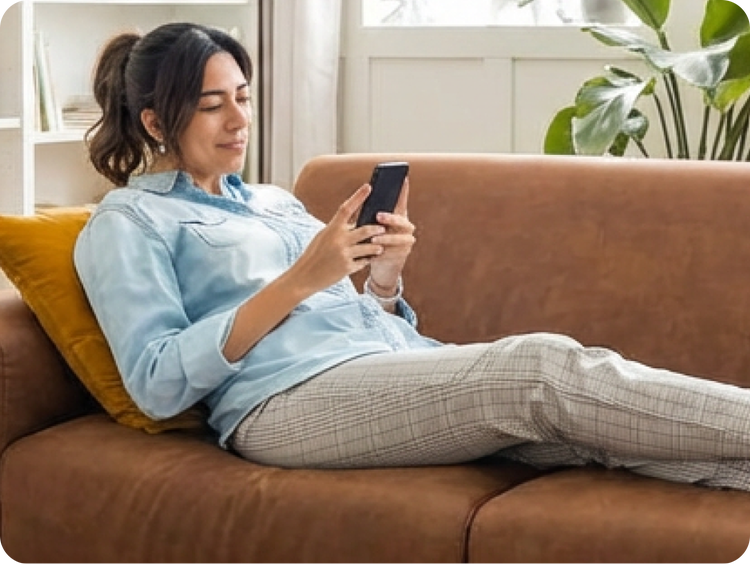Woman on a couch scrolling on her phone