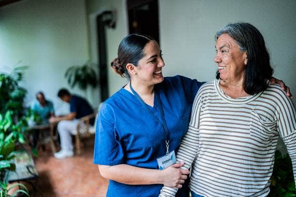 Actor portrayal of a nurse assisting an older adult woman