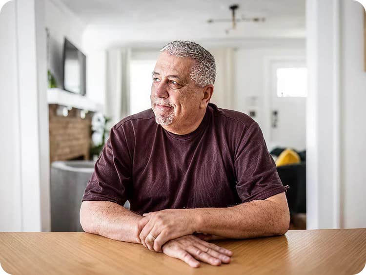 Older adult male seated with a serious expression