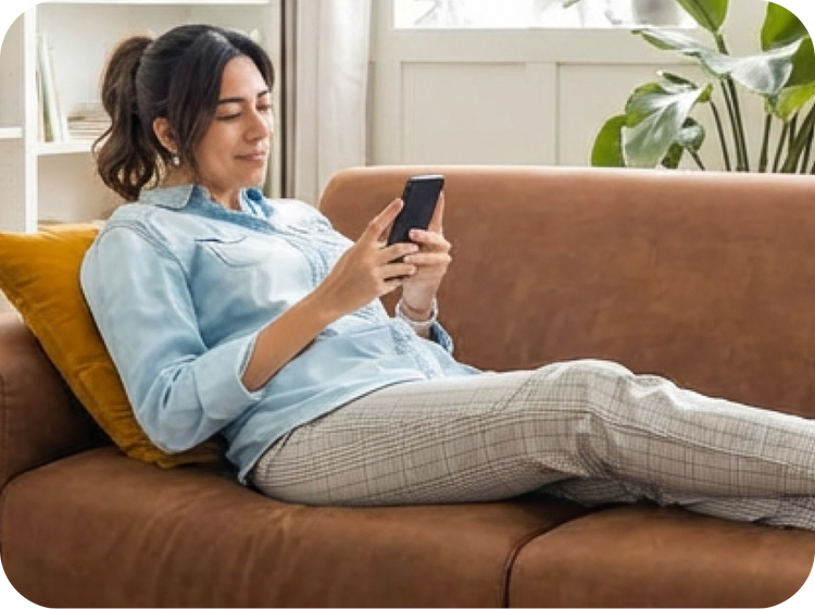 Woman on a couch scrolling on her phone