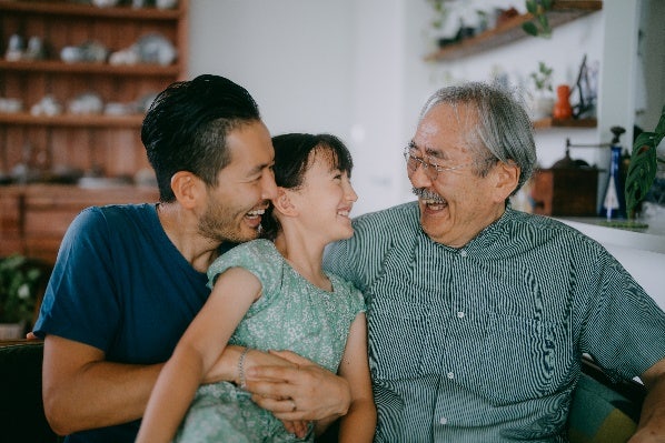 A child laughing with her father and grandfather